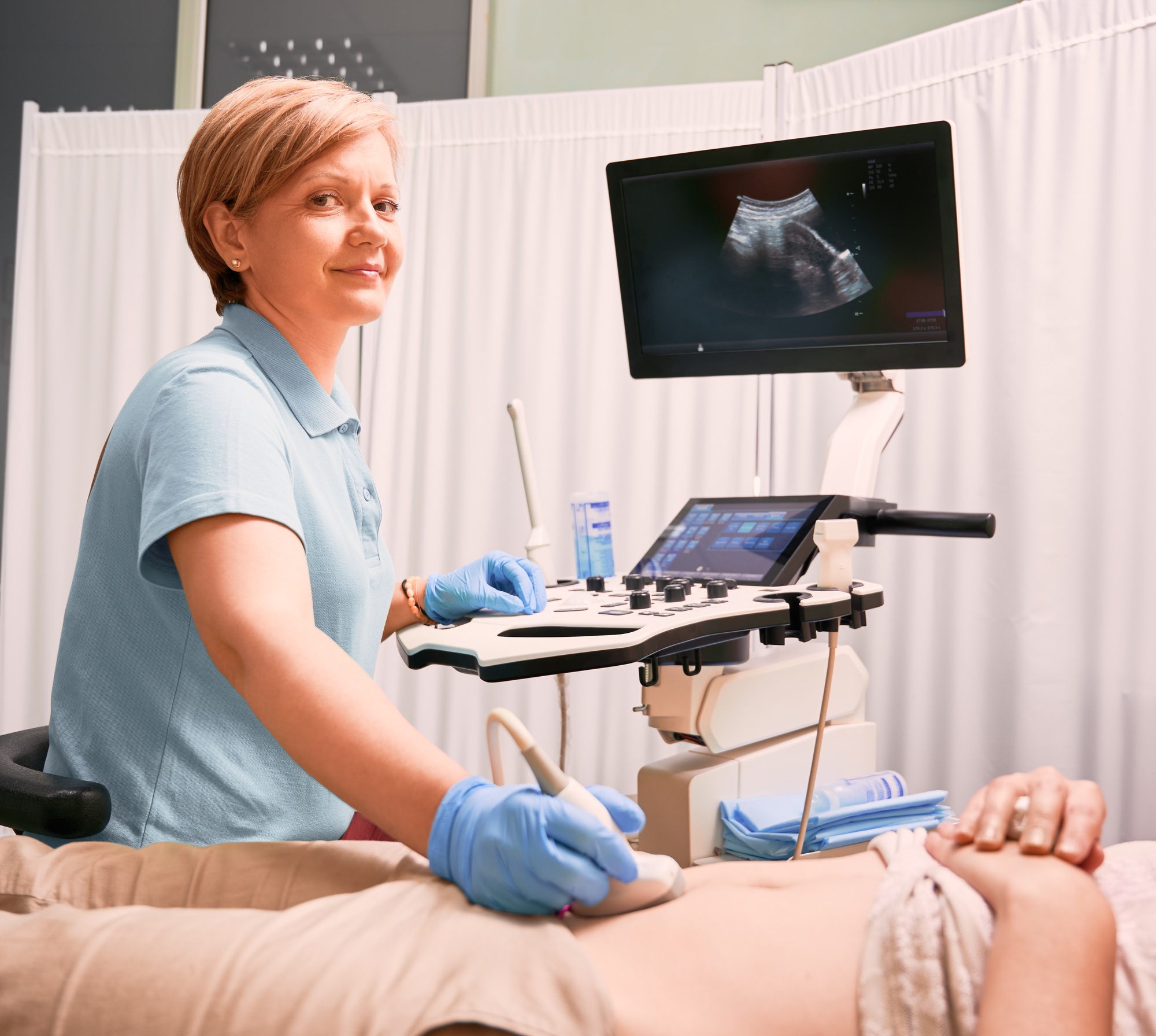 Doctor performing ultrasound procedure in modern clinic.